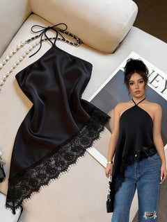 Top halter asimétrico de satín negro con borde de encaje sobre un fondo claro.