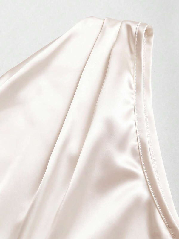 Acercamiento a la textura brillante y sedosa de blusa elegante color crema