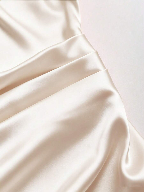 Blusa corta de satín con escote asimétrico estilizando la cintura