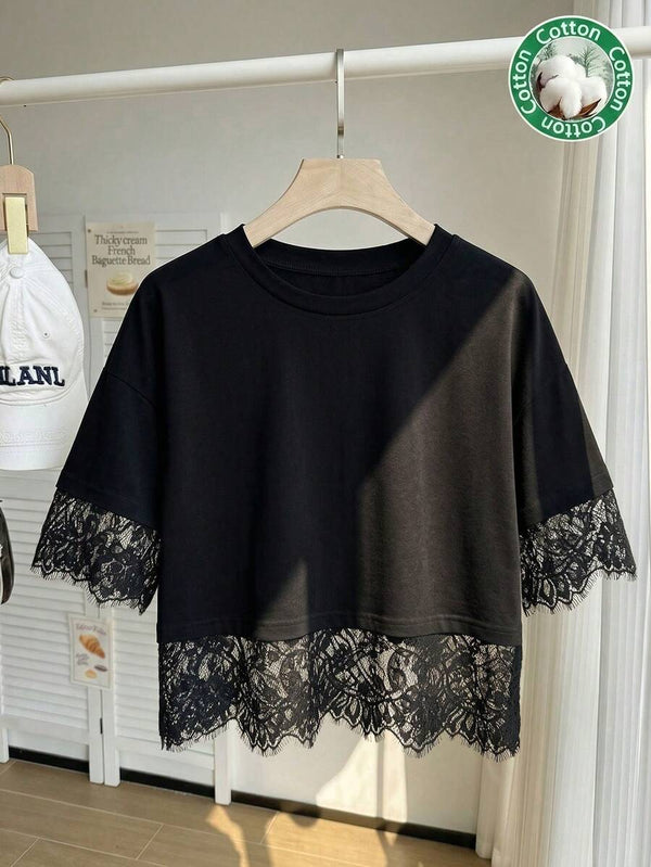 Acercamiento a la textura de algodón y encaje floral de la blusa negra