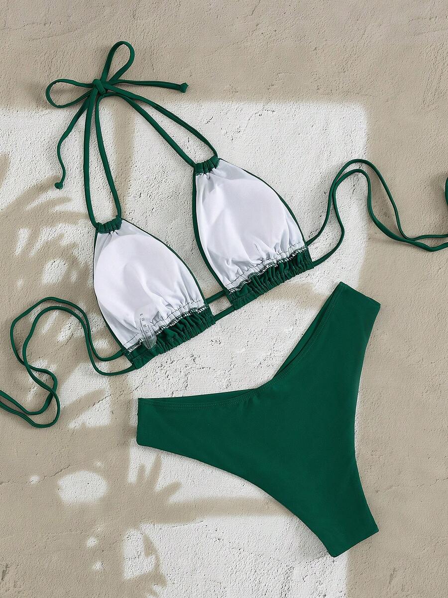 Modelo luciendo un bikini de dos piezas color verde esmeralda con top halter y braga de tiro alto.