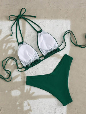 Detalle del top de bikini verde halter con tirantes dobles y collar de conchas.