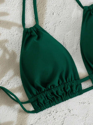 Primer plano de la braga de bikini de tiro alto con diseño cruzado en V en color verde.