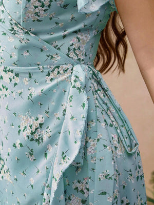 Primer plano del estampado floral blanco y verde sobre el tejido celeste del vestido con bajo de volantes.