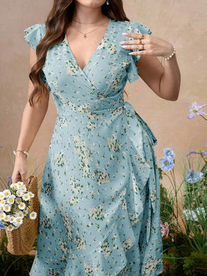 Mujer luciendo un vestido midi cruzado color celeste con estampado floral blanco y mangas de volantes.