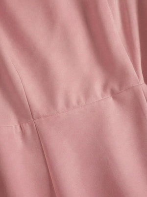 Vista completa del vestido rosa de estilo romántico junto a unos zapatos y perfume.