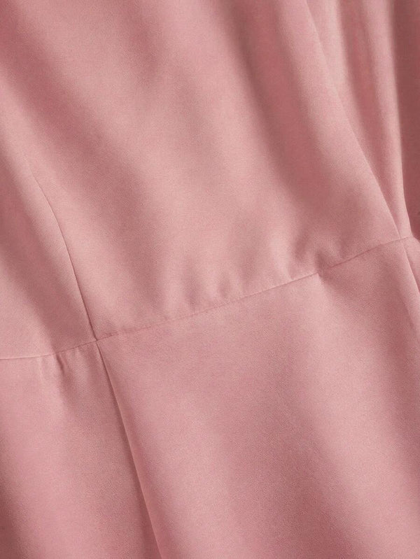 Vista completa del vestido rosa de estilo romántico junto a unos zapatos y perfume.