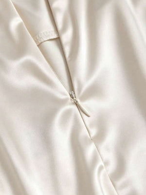 Primer plano del borde de encaje floral en el bajo de la falda blanca.