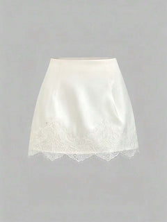 Minifalda blanca satinada con borde de encaje vista frontal.