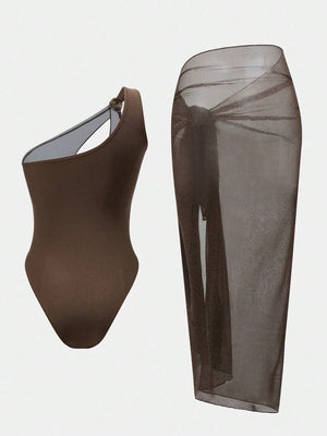 Primer plano del detalle de un hombro del monokini asimétrico con aplique plateado.