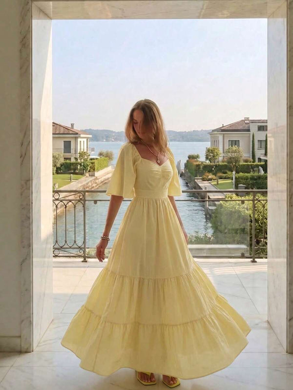Vista de perfil de un vestido amarillo con escote corazón y mangas cortas con vuelo.