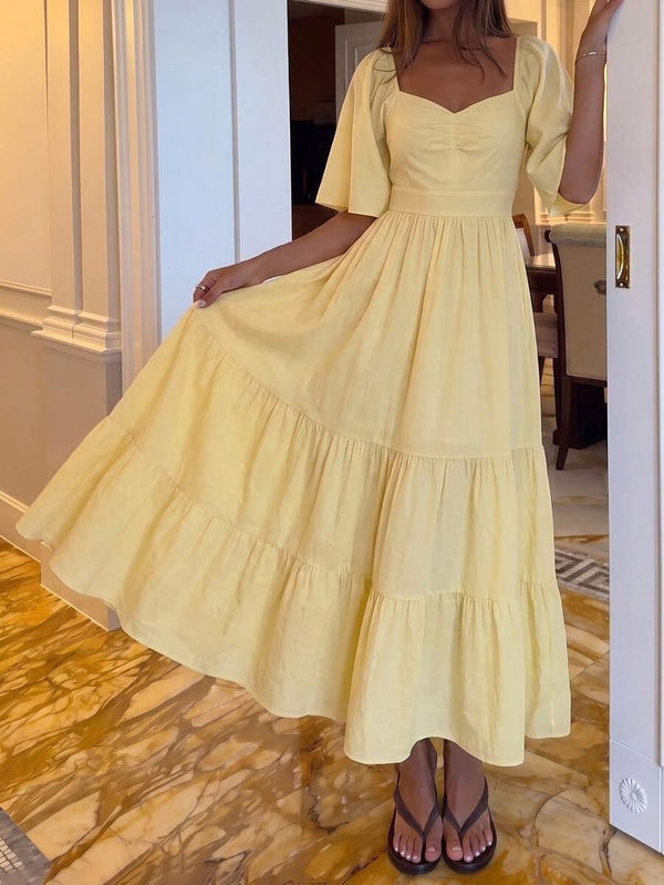 Detalle de la falda larga con niveles de un vestido amarillo estilo bohemio.
