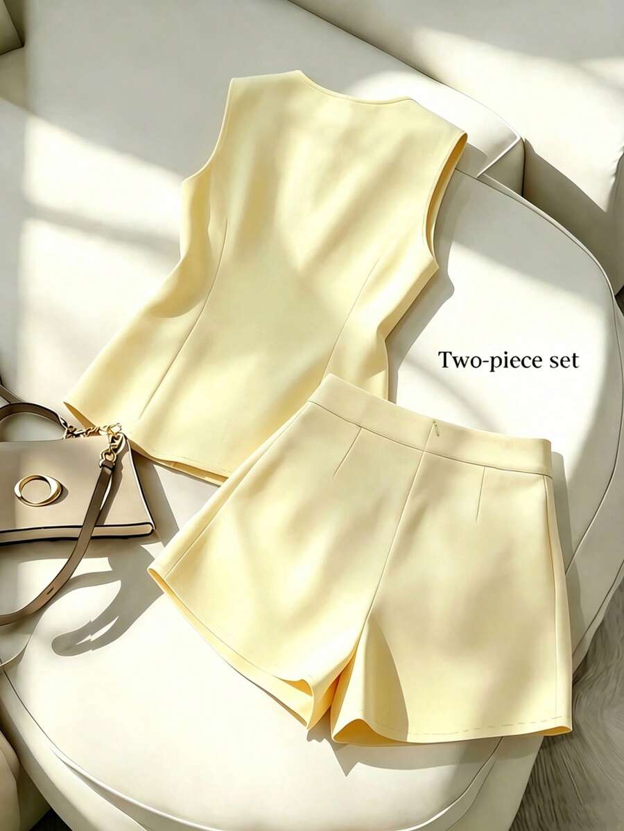Conjunto elegante de chaleco y short amarillo pálido sobre un sillón blanco.
