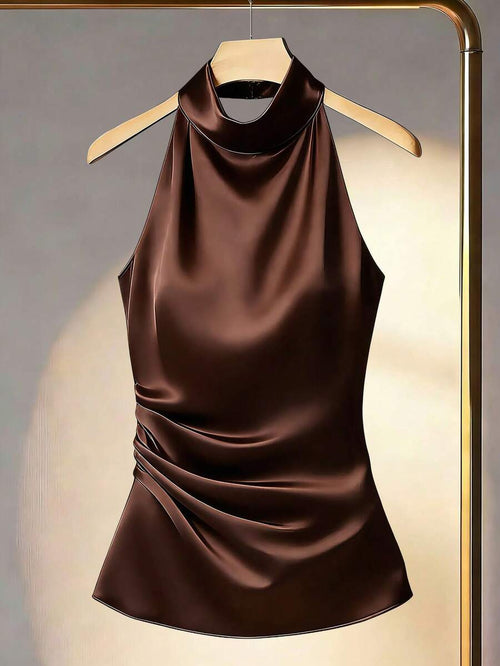 Top halter satinado de color marrón chocolate colgado en una percha dorada, vista frontal.