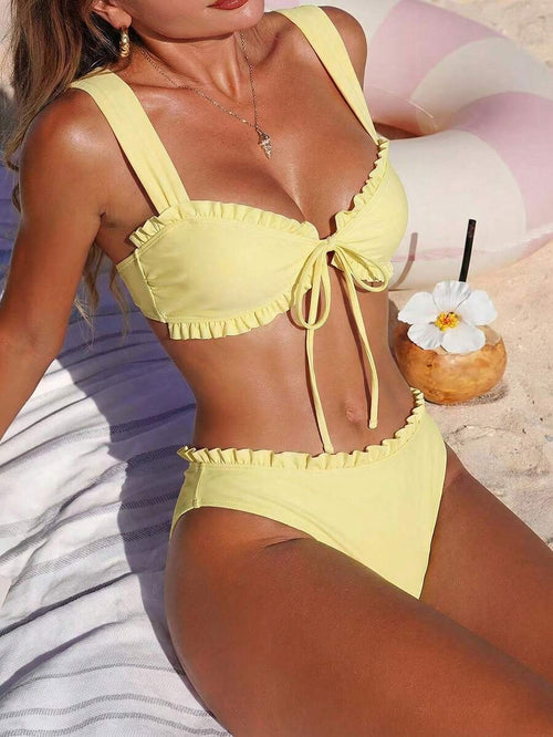 Mujer en la playa vistiendo un bikini amarillo de dos piezas con volantes.