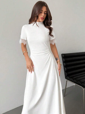 Vestido blanco de cuello alto y caída fluida visto de perfil