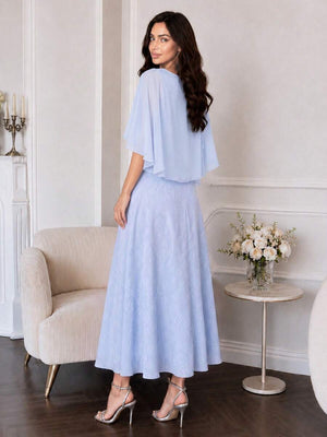 Primer plano del torso de un vestido azul cielo con capa de gasa y mangas acampanadas.