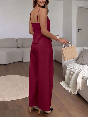 Primer plano del top burdeos con tirantes finos, botones frontales y detalle de peplum en la cintura.