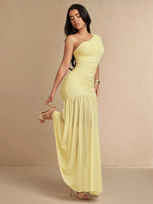 Acercamiento a la textura de malla suave y fruncido en cintura de vestido largo amarillo