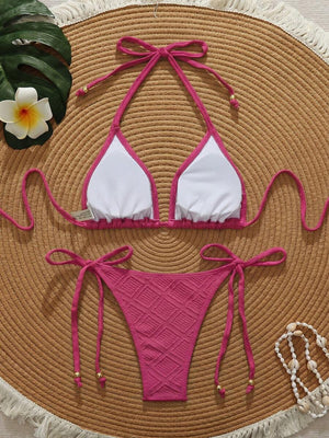 Top de bikini triangular rosa fucsia con textura y lazos al cuello y espalda.