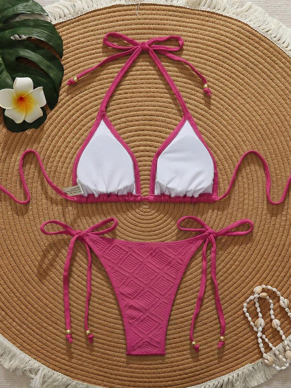 Top de bikini triangular rosa fucsia con textura y lazos al cuello y espalda.