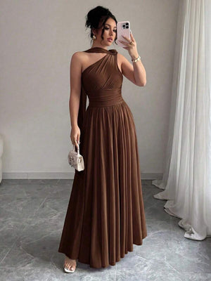 Mujer posando con un vestido largo marrón asimétrico de un solo hombro.