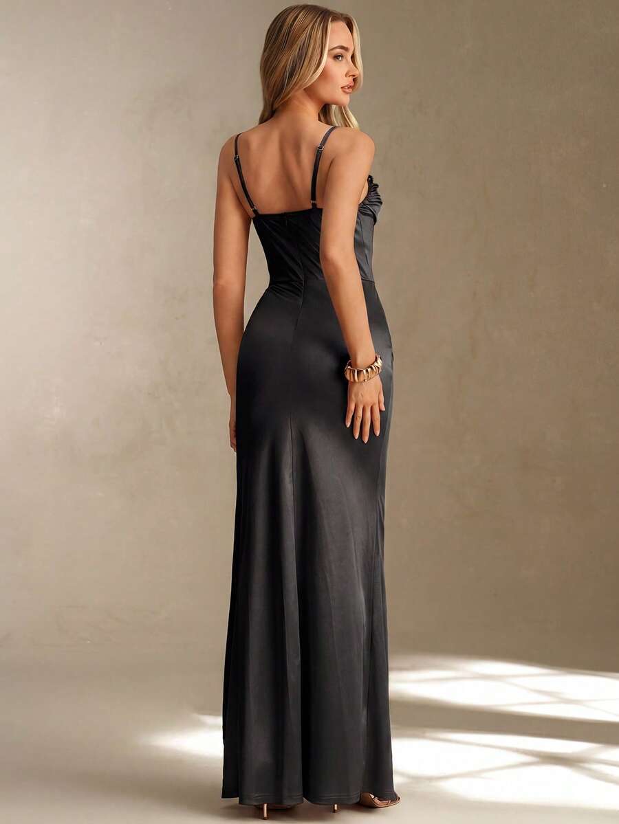 Mujer elegante posando con un vestido largo negro satinado con corsé y abertura lateral.
