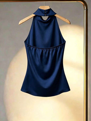 Primer plano del cuello alto tipo halter de una blusa de satén azul marino.