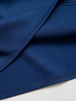 Detalle del drapeado y el tejido satinado de un top elegante sin mangas color azul.