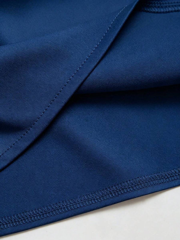 Detalle del drapeado y el tejido satinado de un top elegante sin mangas color azul.