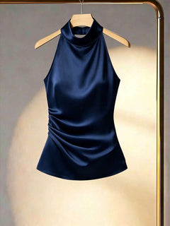 Top satinado azul marino con cuello halter y detalle fruncido en el lateral visto de frente.