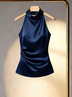 Top satinado azul marino con cuello halter y detalle fruncido en el lateral visto de frente.