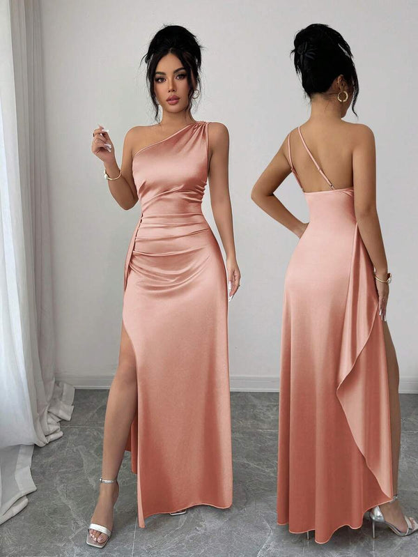 Detalle de la falda maxi de un vestido de noche coral con una pronunciada abertura en la pierna.