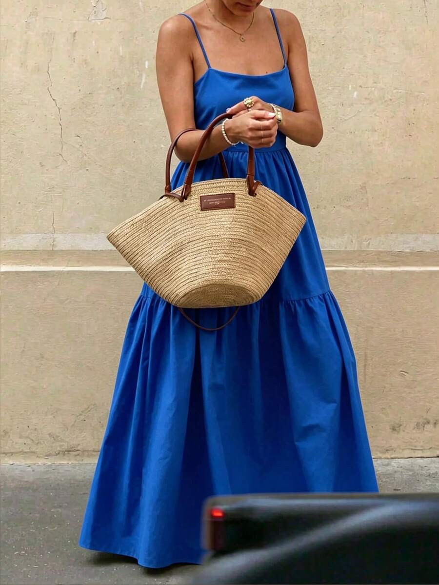 Detalle de la espalda descubierta de un vestido azul con finos tirantes que se cruzan.