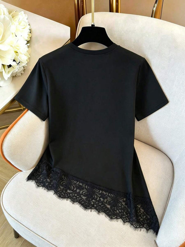 Detalle del cuello redondo y hombro de la blusa negra de tejido liso.