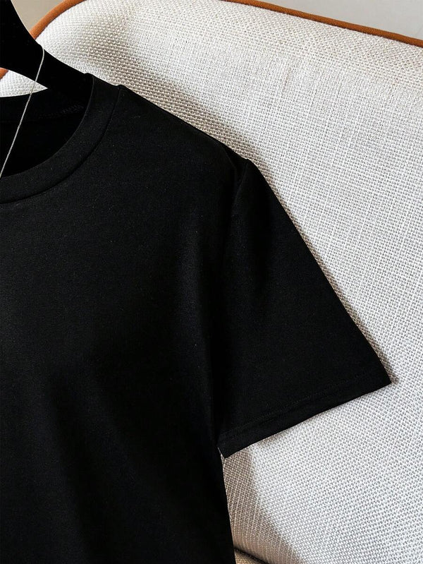 Vista del bajo asimétrico con terminación de encaje floral de la blusa negra.