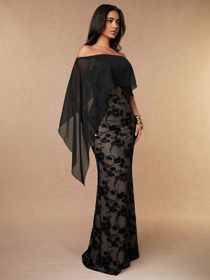 Modelo luciendo un vestido de gala negro entallado con capa y escote de hombros descubiertos.