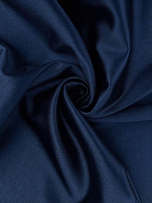 Vista lateral de una mujer con un vestido azul marino ajustado y fruncido.