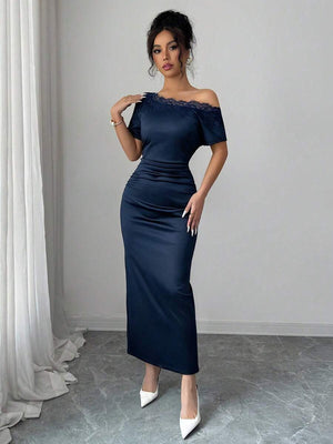 Detalle de la silueta y tela satinada de un vestido midi azul marino.
