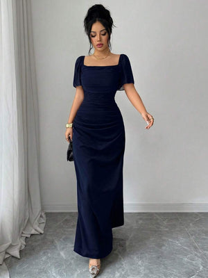 Mujer con un elegante recogido posando de frente con un vestido largo formal azul noche.