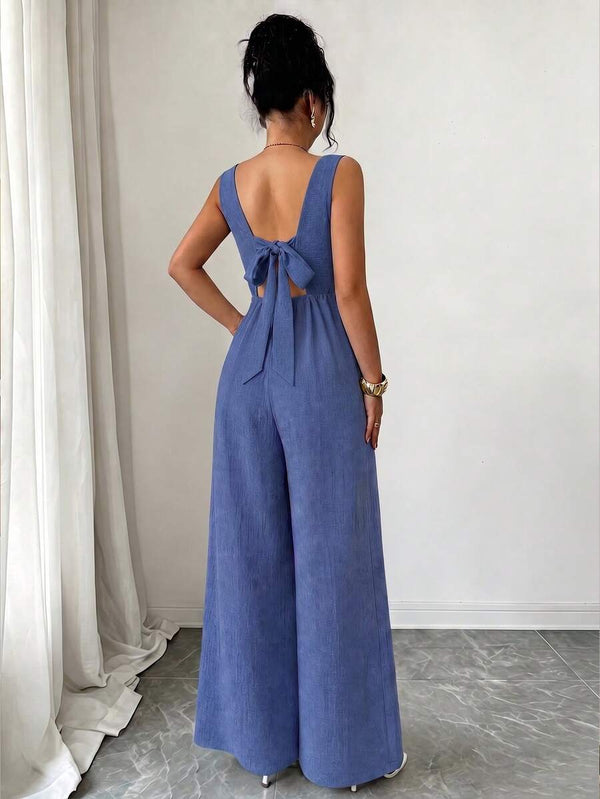Primer plano del torso de un jumpsuit azul con cuello cuadrado y botones decorativos en la cadera.