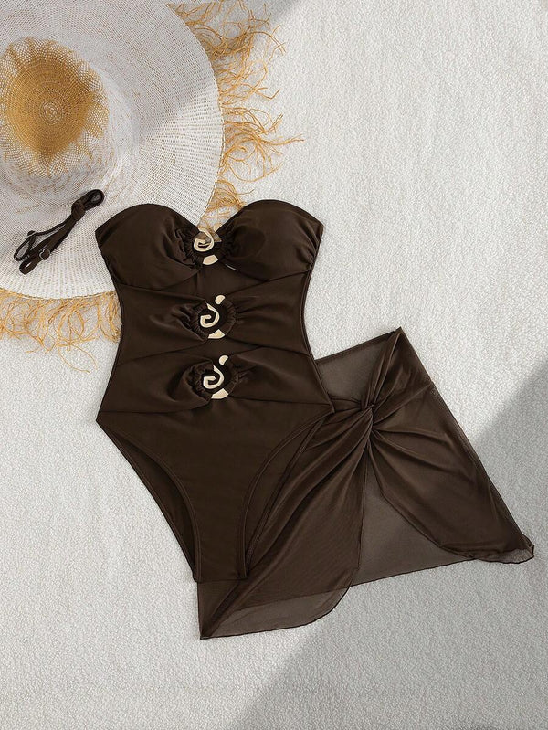 Detalle de la falda del vestido café con nudo frontal y corte asimétrico que estiliza la figura.