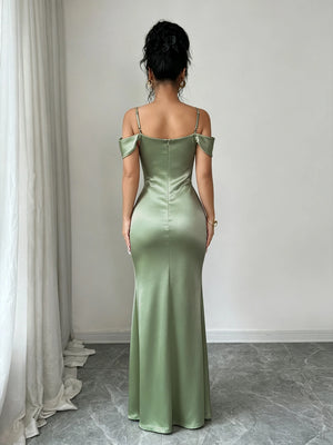 Vista de perfil de una mujer usando un vestido de fiesta verde menta ajustado al cuerpo, mostrando el detalle de los tirantes finos y la espalda.