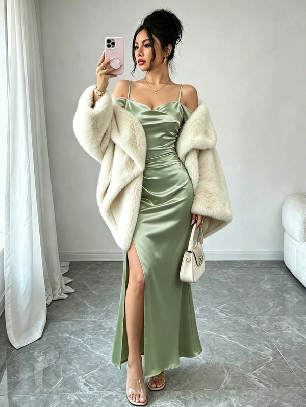 Mujer tomándose una selfie en un espejo luciendo un vestido largo satinado verde con escote drapeado y hombros descubiertos.