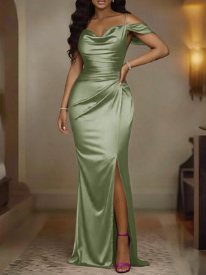 Look completo de mujer con vestido largo verde menta, tacones transparentes y un bolso de mano negro, ideal para eventos formales.