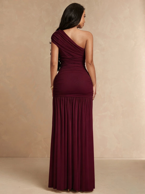 Primer plano del corpiño fruncido de un vestido elegante asimétrico color vino.