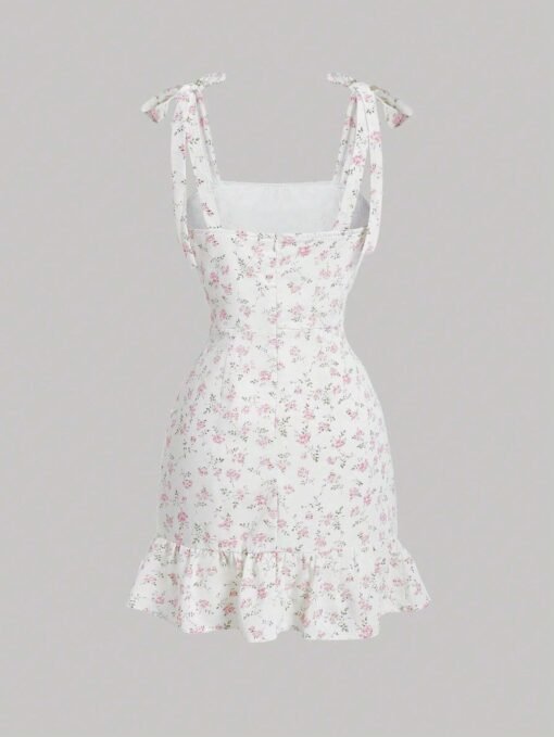 Vestido corto blanco con estampado floral y tirantes de lazo, ideal para ocasiones veraniegas.