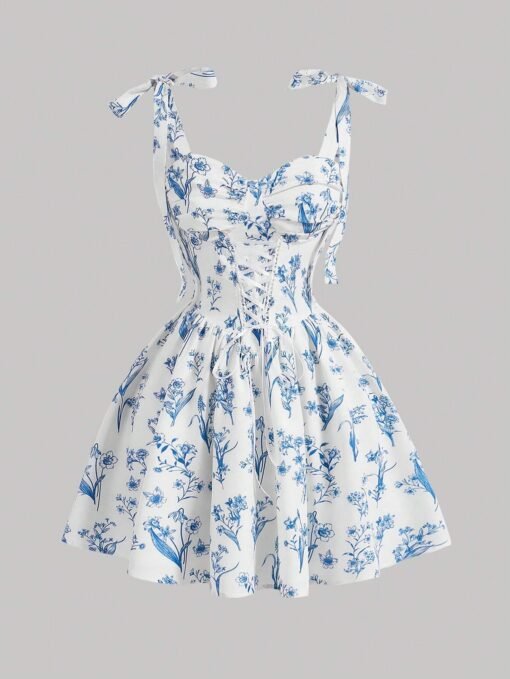 Vestido corto blanco con estampado floral azul y tirantes de lazo, ideal para ocasiones veraniegas.