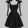 Vestido corto negro con escote fruncido y tirantes de lazo, ideal para ocasiones especiales.