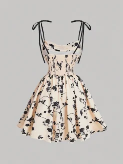 Vestido corto con estampado floral en tonos neutros y negros, con tirantes de lazo, ideal para ocasiones especiales.